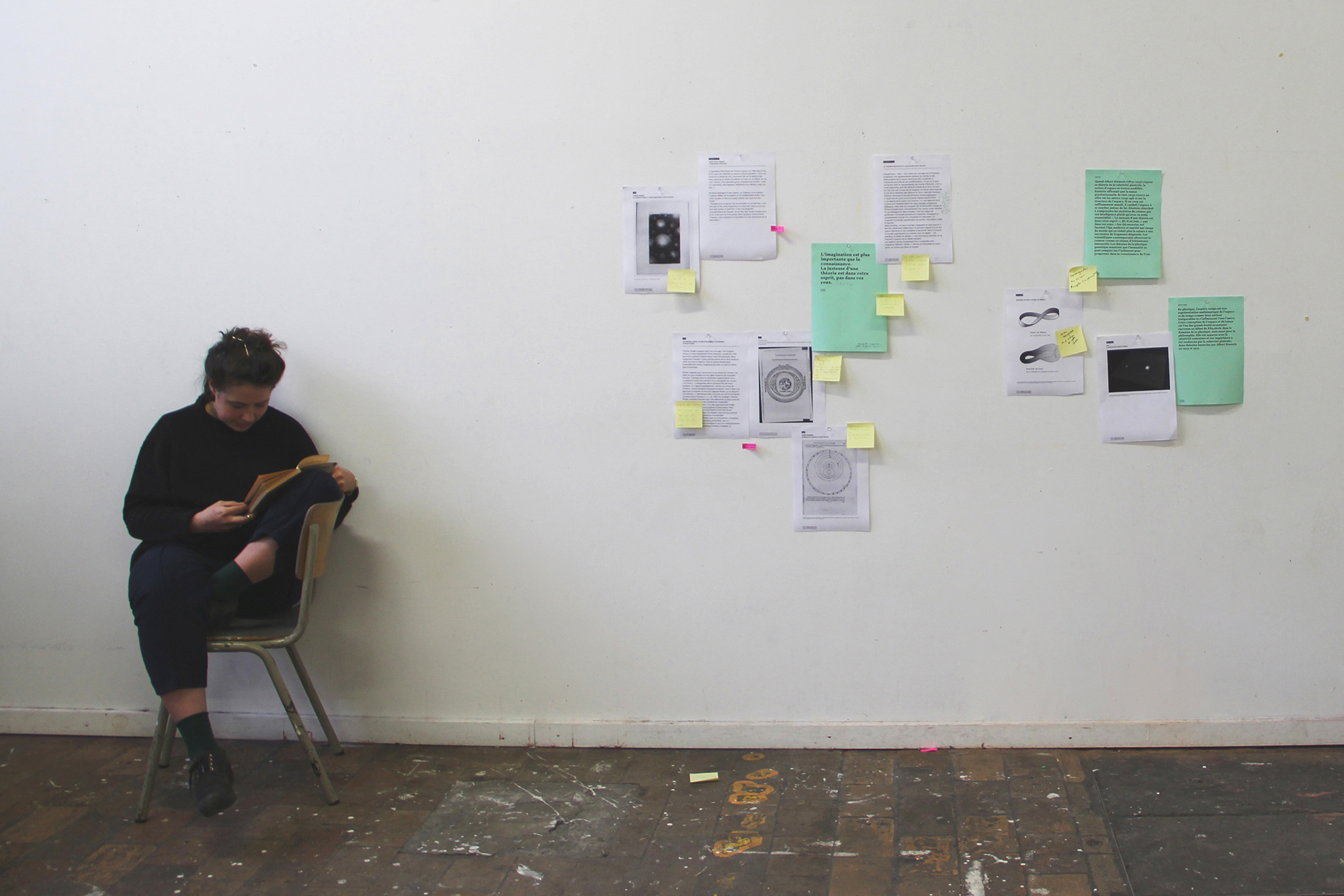 Photographie d'un workshop: feuilles disposées sur un mur